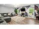 An open concept living room features a fireplace, modern decor, and large windows providing natural light at 100 Chadwick Pl, Villa Rica, GA 30180