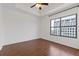 Bright bedroom featuring hardwood floors, ceiling fan, and a large window offering natural light and city views at 3040 Peachtree Nw Rd # 1803, Atlanta, GA 30305