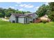 The verdant backyard features a spacious lawn, shed, and multi-level wooden deck at 320 Edna Dr, Stockbridge, GA 30281