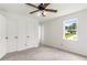 Bright bedroom features a ceiling fan, neutral carpet, and double closets for ample storage space at 320 Edna Dr, Stockbridge, GA 30281