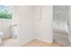 Hallway view of half bathroom and bedroom; features wood-look flooring at 320 Edna Dr, Stockbridge, GA 30281