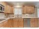 Bright kitchen features wood cabinets, stainless steel dishwasher, and double sink underneath a window at 3467 Clubland Dr, Marietta, GA 30068