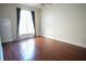 Bedroom featuring hardwood floors, one window with curtains, and a white door at 1010 Forest Overlook Sw Dr, Atlanta, GA 30331