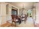 Formal dining room with a large table, elegant chandelier, and arched windows overlooking the backyard at 179 Worthington Way, Jonesboro, GA 30236
