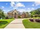 Stunning brick home featuring a manicured front yard, a long driveway, and beautiful architectural details at 179 Worthington Way, Jonesboro, GA 30236