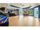 Expansive game room with an arcade game, seating area, game table, and large windows at 179 Worthington Way, Jonesboro, GA 30236