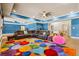 Spacious living room featuring a colorful rug, a large leather sectional, and a ceiling fan at 179 Worthington Way, Jonesboro, GA 30236