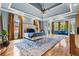 Luxurious main bedroom featuring tray ceilings, a fireplace, and a seating area with beautiful views at 179 Worthington Way, Jonesboro, GA 30236