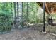 The backyard features mature trees, natural landscaping, and a covered area providing shade and storage at 248 Riverview Trl, Roswell, GA 30075