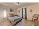 Bright bedroom features wood floors, a decorative lamp, and a cozy chair by the window at 248 Riverview Trl, Roswell, GA 30075