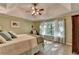 Inviting bedroom featuring a ceiling fan, tray ceiling, large windows, and warm, natural light at 248 Riverview Trl, Roswell, GA 30075
