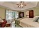 Bright bedroom featuring tray ceilings, sitting area, barn door to bath, and large windows at 248 Riverview Trl, Roswell, GA 30075