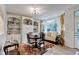 Bright dining area with built-in shelving, seating, a round table, and a large bay window overlooking greenery at 248 Riverview Trl, Roswell, GA 30075
