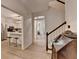 Hallway featuring light wood flooring, leading to an open kitchen and stairway, providing a spacious feel at 248 Riverview Trl, Roswell, GA 30075