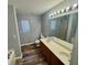 Bathroom featuring dual sinks, well-lit vanity, and a jacuzzi tub, perfect for ultimate comfort and convenience at 2572 Laurel Cir, Atlanta, GA 30311