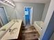 Bathroom featuring double sinks, a separate tub, and a view to another room in an open and airy layout at 2572 Laurel Cir, Atlanta, GA 30311