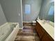 Bathroom with sleek vanity, a tub for relaxation, and wood-look flooring that combines style and practicality at 2572 Laurel Cir, Atlanta, GA 30311