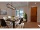 Bright dining room with modern light fixture, hardwood floors, and a large window showcasing the yard at 3007 Holly St, Canton, GA 30115