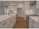 Bright kitchen features white cabinets, a farmhouse sink, stainless steel appliances, and hardwood floors at 3007 Holly St, Canton, GA 30115