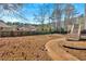 A view of the expansive backyard, featuring a garden, mature trees, and privacy fence at 2021 Cockrell Pointe Nw, Kennesaw, GA 30152