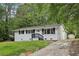 Attractive one-story white home with black shutters, front yard, and long driveway at 2765 Ocean Valley Dr, Atlanta, GA 30349