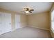 Bedroom with neutral carpet, a ceiling fan, and two closets at 4400 Village Field Pl, Suwanee, GA 30024