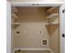 Empty utility closet with shelving and connections ready for washer and dryer at 4400 Village Field Pl, Suwanee, GA 30024