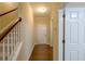Hallway with hardwood floors, white doors, and a view of the stairs at 4400 Village Field Pl, Suwanee, GA 30024