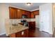 Well-lit kitchen features granite counters, wood cabinets, stainless steel appliances, and hardwood floors at 4400 Village Field Pl, Suwanee, GA 30024