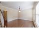 Bright living room features hardwood floors, crown molding, and a light fixture at 4400 Village Field Pl, Suwanee, GA 30024