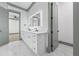 Bathroom showcasing a double vanity with illuminated mirror, white cabinets, and marble floors at 632 Hunters Cove Ln., Loganville, GA 30052
