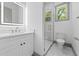 Bright bathroom features a glass-enclosed shower, white vanity, and marble flooring at 632 Hunters Cove Ln., Loganville, GA 30052