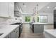 Long kitchen view with white cabinets, quartz countertops, stainless steel appliances, large windows and gray island at 632 Hunters Cove Ln., Loganville, GA 30052