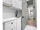 Laundry room area with white cabinets, black fixtures, and a marble countertop at 632 Hunters Cove Ln., Loganville, GA 30052