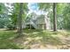 Backyard with a well-maintained lawn, mature trees, and a basketball area; ideal for outdoor activities at 7533 Mason Falls Dr, Winston, GA 30187