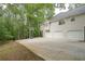 Backyard showing a multi-car garage and a basketball hoop adjacent to a lovely wooded area at 7533 Mason Falls Dr, Winston, GA 30187