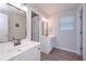 Bathroom featuring light-colored wood look flooring, a window, and double sink vanity with white cabinets at 7533 Mason Falls Dr, Winston, GA 30187