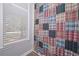 Charming bathroom featuring a colorful patchwork-patterned shower curtain and natural light from the window at 7533 Mason Falls Dr, Winston, GA 30187
