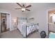 Neutral bedroom featuring a ceiling fan, a doorway to the bathroom, and a view to the kitchen at 7533 Mason Falls Dr, Winston, GA 30187