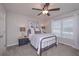 Cozy bedroom with a wrought iron bed frame, gray carpet, and bright natural lighting from a window at 7533 Mason Falls Dr, Winston, GA 30187