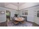 Elegant dining room featuring a tray ceiling, chandelier, and a round table set for dinner at 7533 Mason Falls Dr, Winston, GA 30187