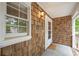 Covered porch featuring cedar shingles, white trim and brick stairs at 7533 Mason Falls Dr, Winston, GA 30187