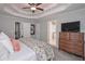 A spacious main bedroom with tray ceiling, fan, and view to the main bath at 7533 Mason Falls Dr, Winston, GA 30187