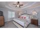 A spacious main bedroom with tray ceiling, fan, and decorative mirror at 7533 Mason Falls Dr, Winston, GA 30187