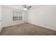 Bright bedroom with neutral carpet, ceiling fan, and large window at 105 Hunters, Mcdonough, GA 30253