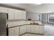 Open kitchen with white cabinets and counters, with bar pass-through to the living area at 105 Hunters, Mcdonough, GA 30253