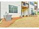 Backyard featuring an A/C unit, mulch bed, and view of a balcony on the back of the house at 1122 Provence Ln, Decatur, GA 30033