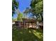 Backyard view featuring a raised patio, green grass, and mature trees at 1461 Alverado Way, Decatur, GA 30032