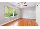 Sunny bedroom with hardwood floors, ceiling fan, and a large window overlooking a green yard at 1461 Alverado Way, Decatur, GA 30032