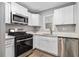 Modern kitchen with stainless steel appliances, white cabinets, quartz countertops, and hardwood floors at 1461 Alverado Way, Decatur, GA 30032